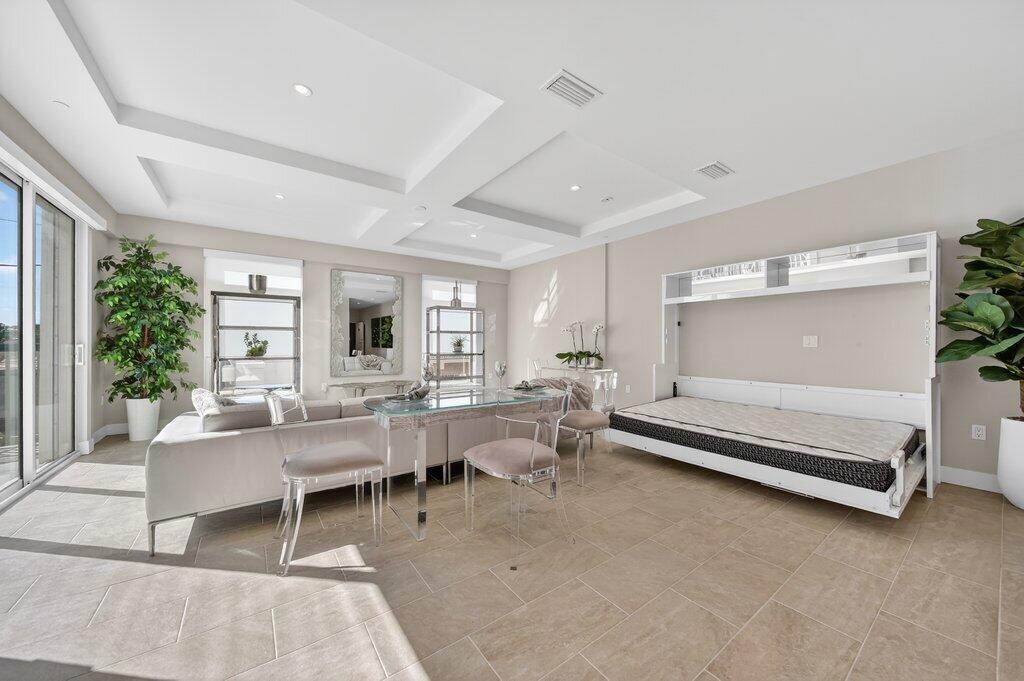 41 Southwest Seminole Street, Unit 209 Stuart, FL 34994 - Photo 5 of 26 a living room with furniture a rug and a large window