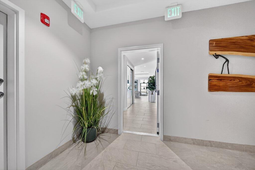 41 Southwest Seminole Street, Unit 209 Stuart, FL 34994 - Photo 6 of 26 an entryway with a flower pot and a bookshelf