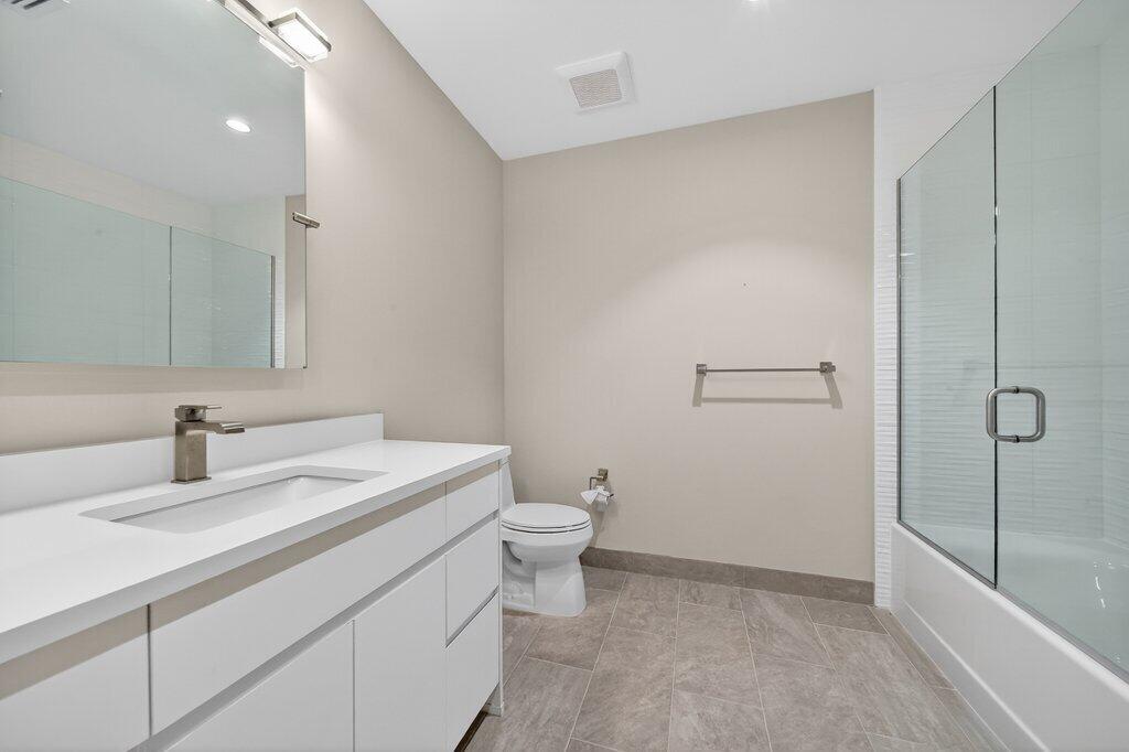 41 Southwest Seminole Street, Unit 209 Stuart, FL 34994 - Photo 9 of 26 a bathroom with a sink a toilet and shower