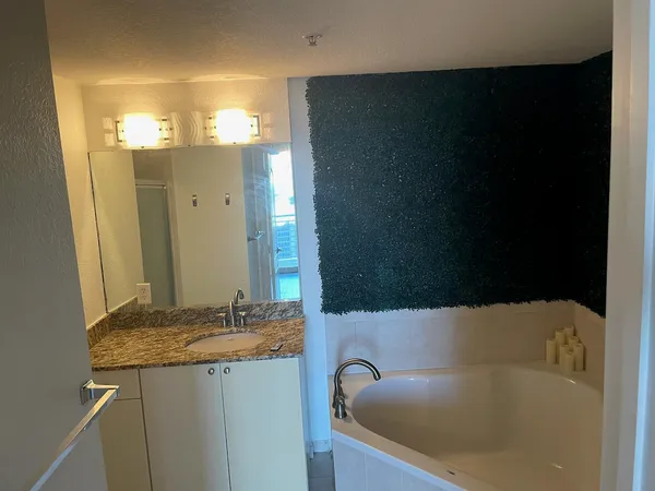 a bathroom with a granite countertop sink and a mirror