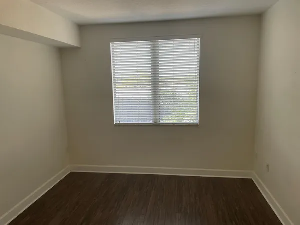 an empty room with wooden floor and a window