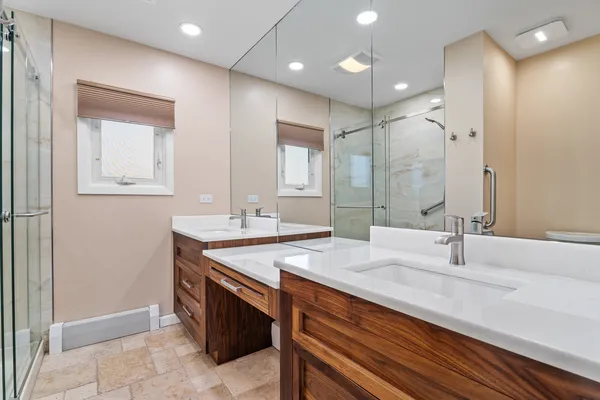 a bathroom with a double vanity sink mirror double and shower