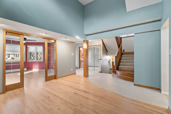 a view of an empty room with wooden floor and stairs