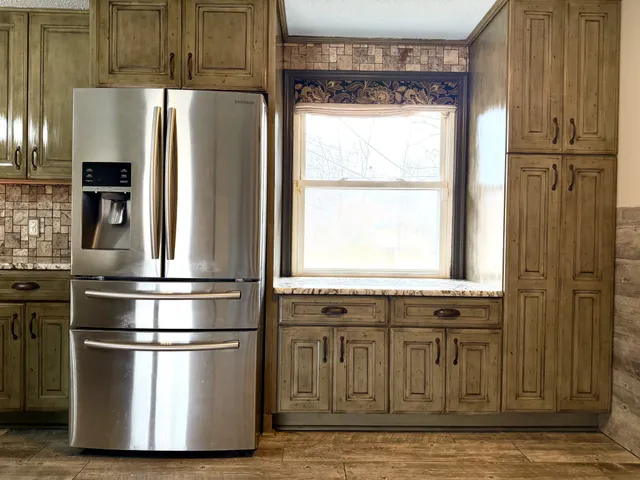 a kitchen with stainless steel appliances granite countertop a refrigerator and a stove