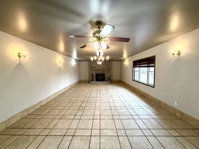 a view of an empty room and a chandelier fan