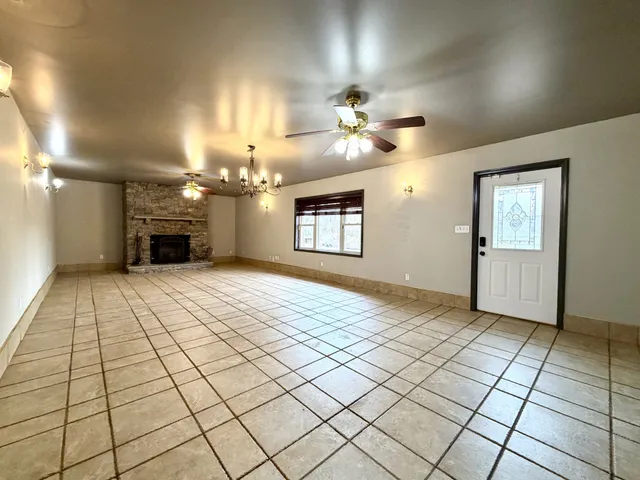 a view of a livingroom with a chandelier fan and fire place