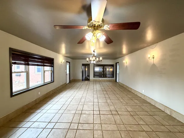 a view of an empty room and window and a kitchen