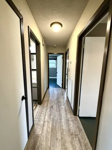 a view of a hallway with wooden floor and staircase