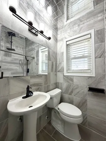 a bathroom with a sink toilet and a mirror