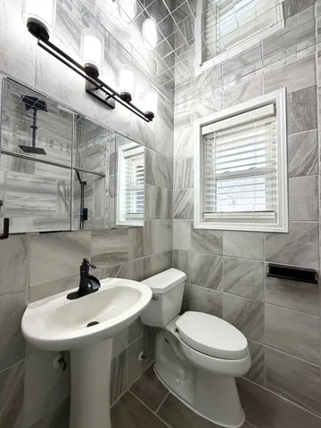 a bathroom with a sink toilet and a mirror
