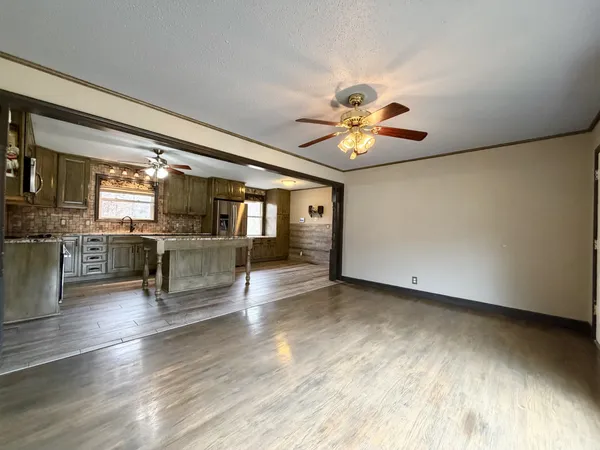 a view of kitchen and living room with wooden floor