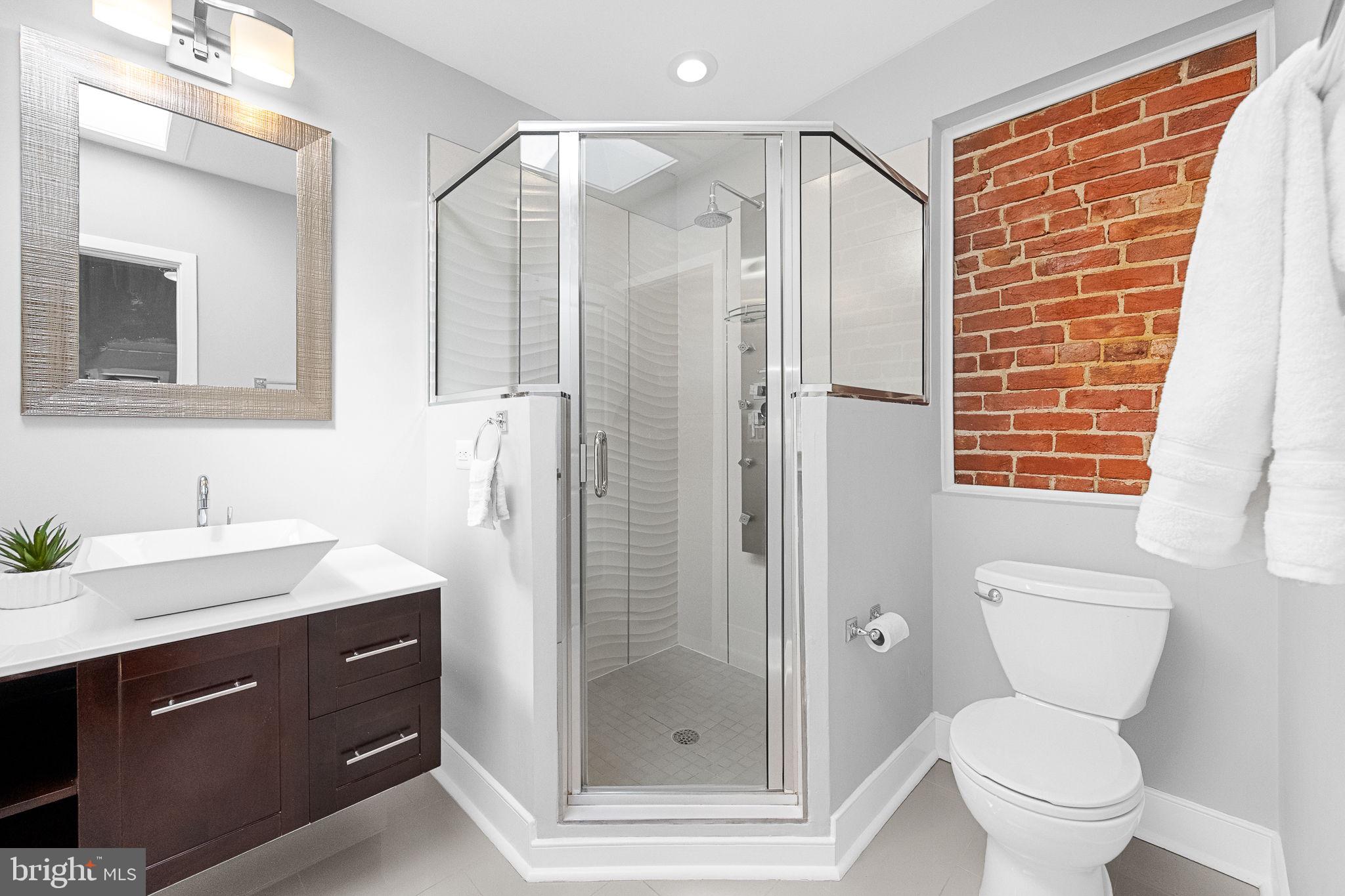 2819 11th Street Northwest, Unit 2 Washington, DC 20001 - Photo 29 of 36 a bathroom with a shower sink vanity mirror and toilet