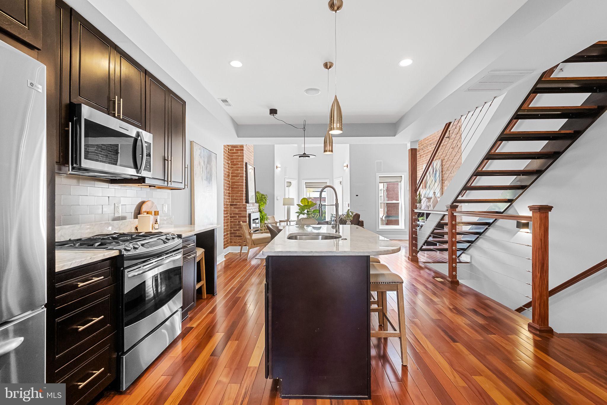 2819 11th Street Northwest, Unit 2 Washington, DC 20001 - Photo 4 of 36 a kitchen with stainless steel appliances granite countertop a refrigerator a stove top oven a sink dishwasher and wooden cabinets with wooden floor