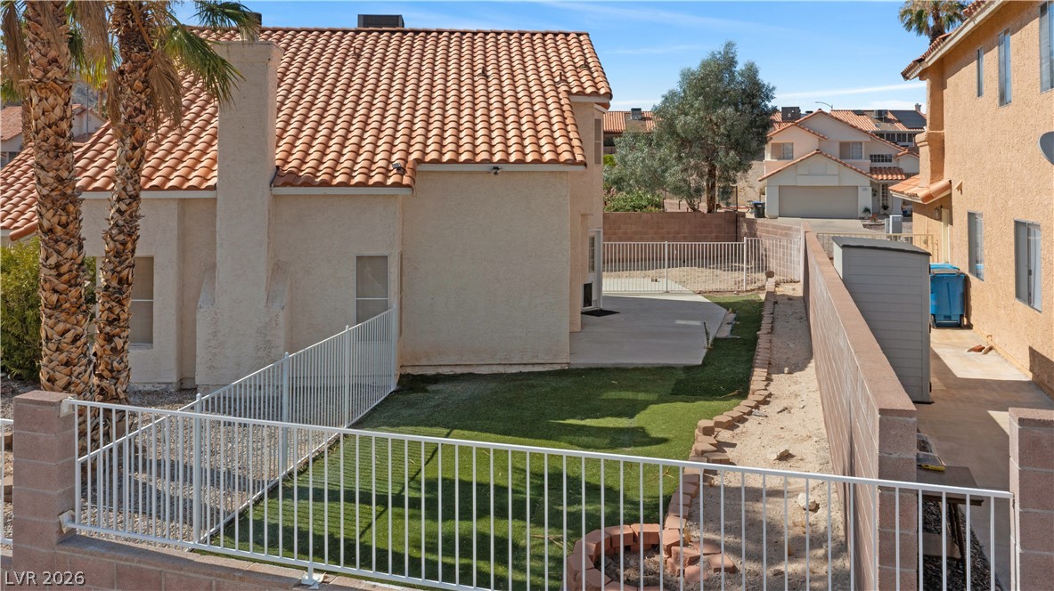 3156 Terrace View Drive Laughlin, NV 89029 - Photo 82 of 94 A well-maintained side yard features a mix of artificial turf and desert landscaping, enclosed by sturdy fencing.