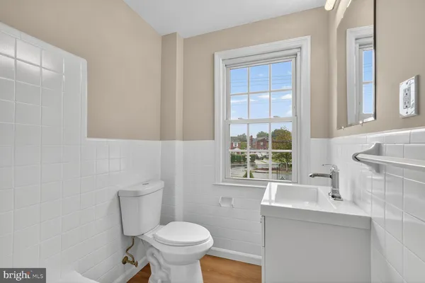 a bathroom with a sink toilet and window