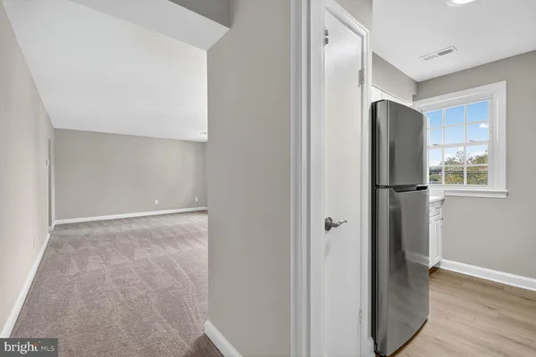 a view of hallway with a large window and wooden floor