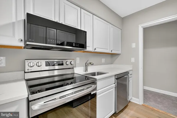 a kitchen with stainless steel appliances a stove microwave and cabinets