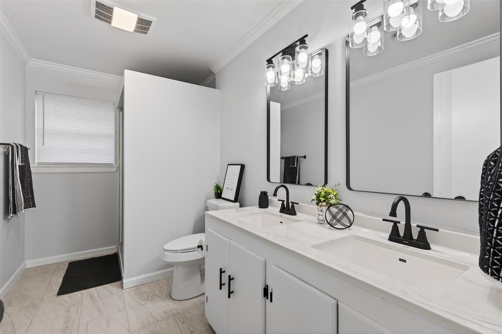 522 Lee Street Mansfield, LA 71052 - Photo 14 of 20 a bathroom with a sink a toilet and a large mirror