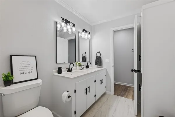 a bathroom with a double vanity sink mirror and toilet