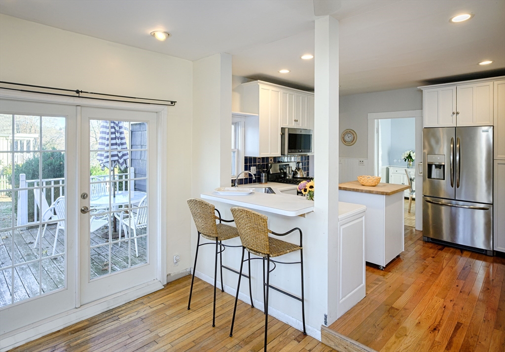 31 Marion Street Natick, MA 01760 - Photo 11 of 32 a kitchen with stainless steel appliances a dining table chairs refrigerator and cabinets