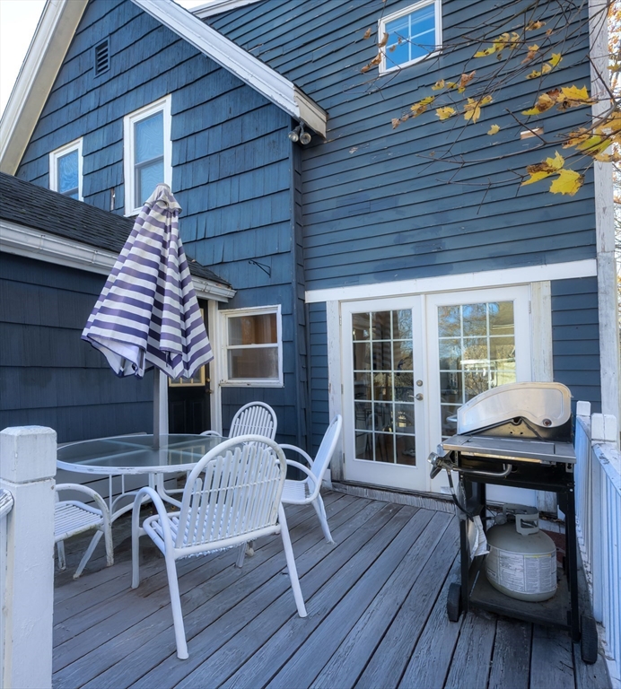 31 Marion Street Natick, MA 01760 - Photo 12 of 32 a view of a deck with table and chairs with wooden floor and fence