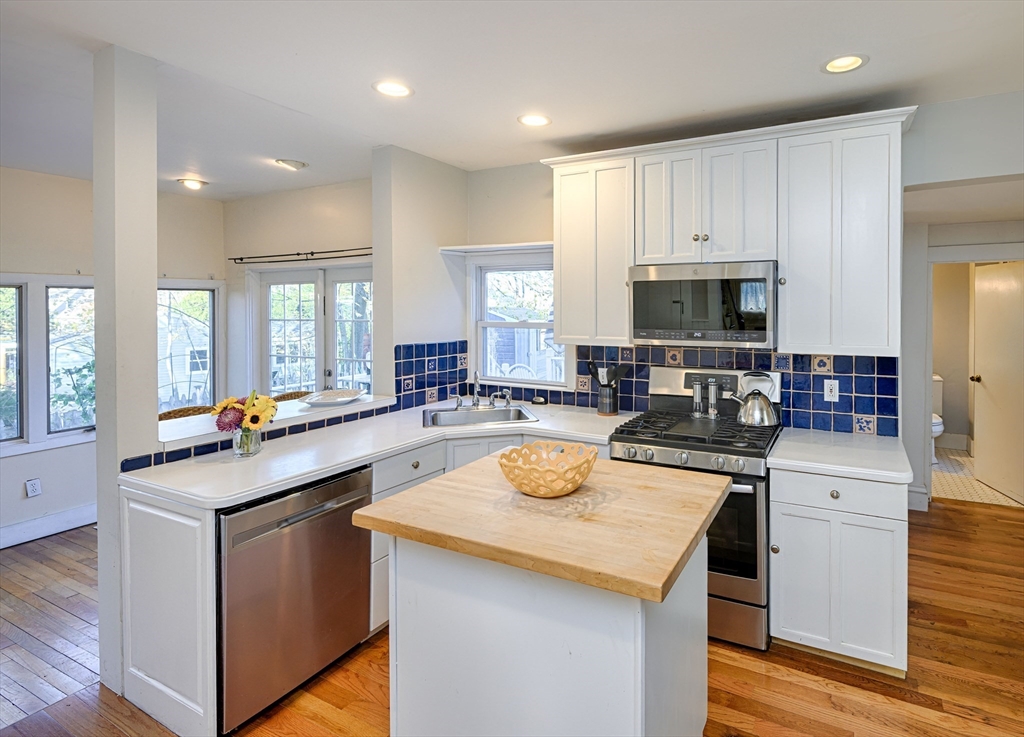 31 Marion Street Natick, MA 01760 - Photo 9 of 32 a kitchen with a sink a stove cabinets and wooden floor