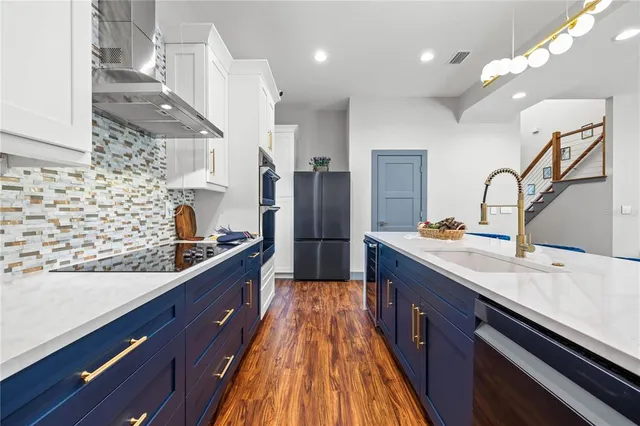 a large kitchen with stainless steel appliances kitchen island granite countertop a sink stove and refrigerator