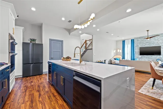 a kitchen with stainless steel appliances a sink and a refrigerator