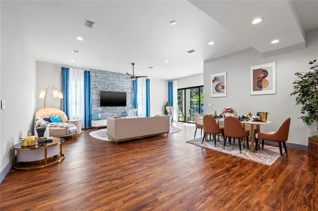 a living room with furniture flat screen tv and a wooden floor