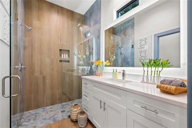 a bathroom with a granite countertop sink a mirror and a shower