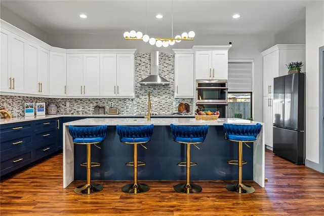 a kitchen with stainless steel appliances kitchen island granite countertop a refrigerator and stove