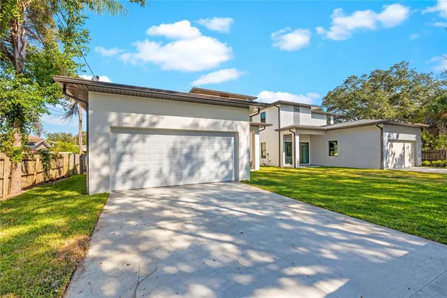 a view of a house with brick walls and a yard with plants