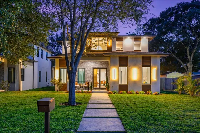 a front view of a house with a yard and trees