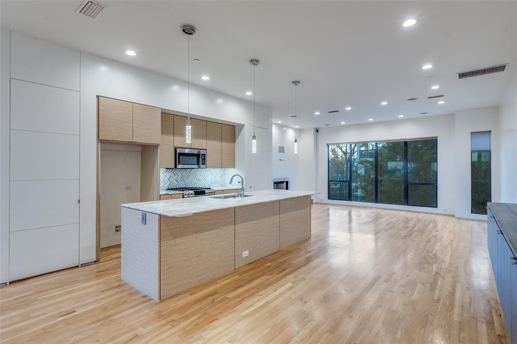 1505 North Haskell Avenue, Unit 3 Dallas, TX 75204 - Photo 11 of 28 a large kitchen with stainless steel appliances granite countertop a large counter top a stove and a refrigerator
