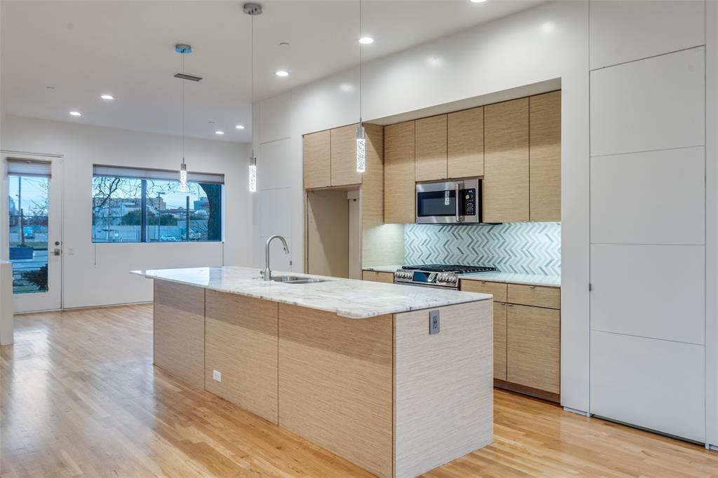 1505 North Haskell Avenue, Unit 3 Dallas, TX 75204 - Photo 13 of 28 a kitchen with kitchen island a sink stainless steel appliances and cabinets