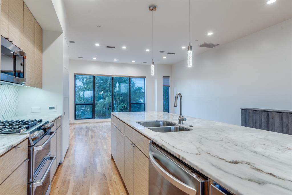 1505 North Haskell Avenue, Unit 3 Dallas, TX 75204 - Photo 9 of 28 a kitchen with granite countertop a sink a counter top space stove and cabinets