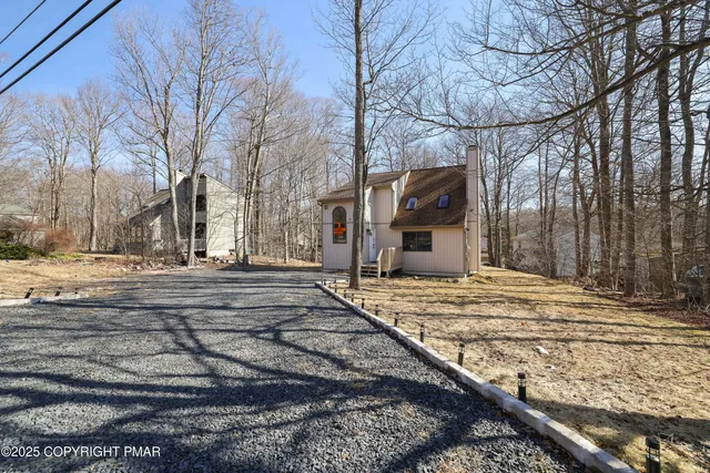 a view of a white house with a yard next to a road