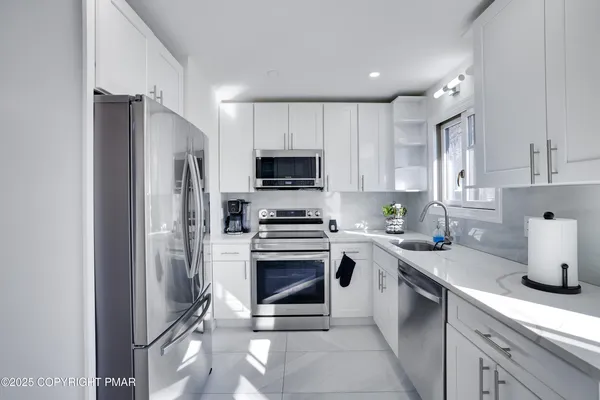 a kitchen with a sink stainless steel appliances and cabinets
