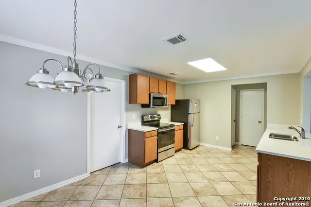 a kitchen with stainless steel appliances granite countertop a sink and a refrigerator