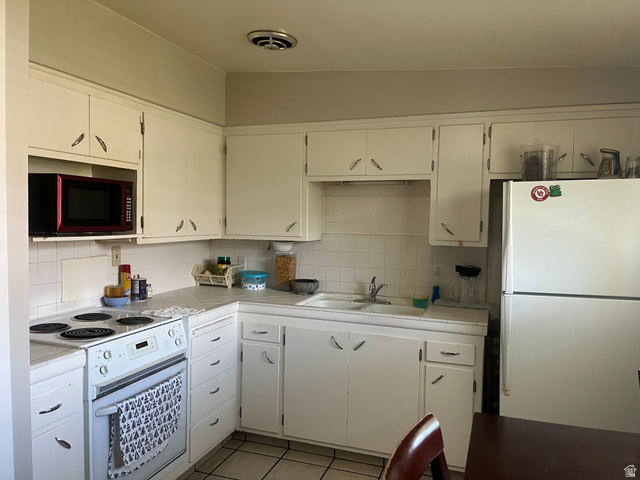 456 500 South Bountiful, UT 84010 - Photo 10 of 19 Kitchen with white appliances, light tile patterned flooring, white cabinetry, and decorative backsplash