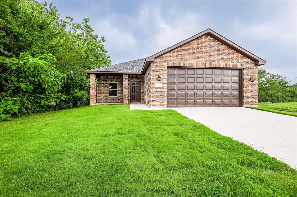 a front view of a house with yard and green space