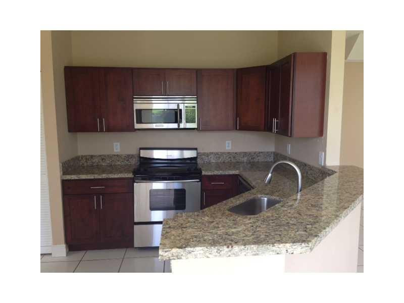 949 Falling Water Road Weston, FL 33326 - Photo 4 of 12 a kitchen with a sink a stove and cabinets