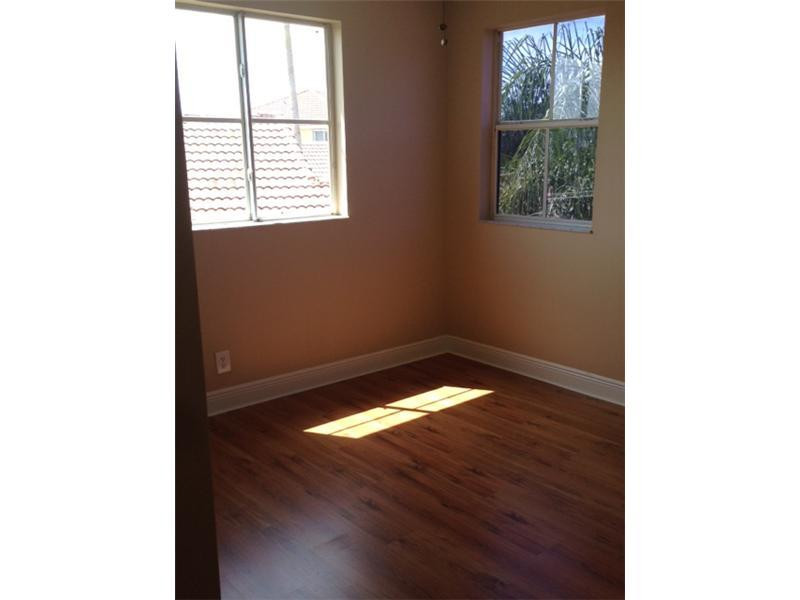 949 Falling Water Road Weston, FL 33326 - Photo 7 of 12 a view of an empty room with wooden floor and a window