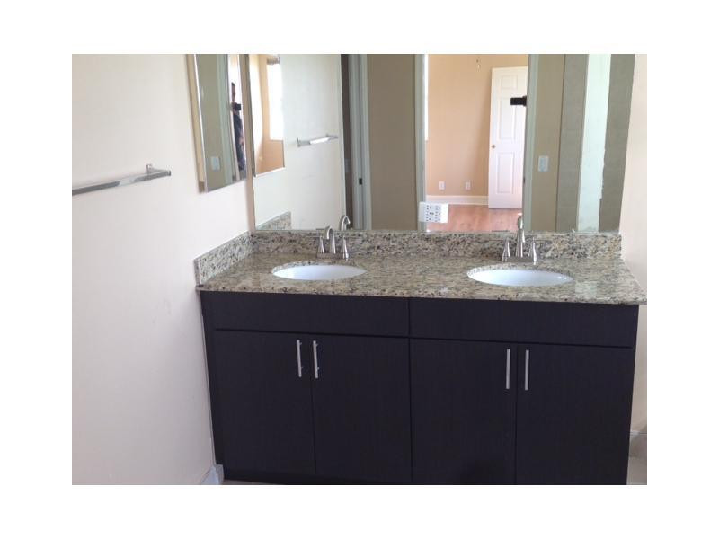 949 Falling Water Road Weston, FL 33326 - Photo 8 of 12 a bathroom with a sink a mirror and a toilet
