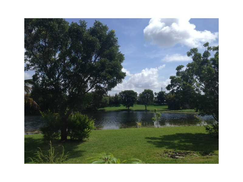 949 Falling Water Road Weston, FL 33326 - Photo 10 of 12 a view of a lake with a yard