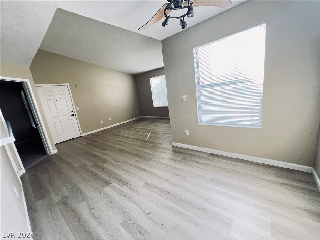 8101 West Flamingo Road, Unit 2161 Las Vegas, NV 89147 - Photo 7 of 15 High ceilings crown this spacious living area, featuring light hardwood-style flooring and natural light.