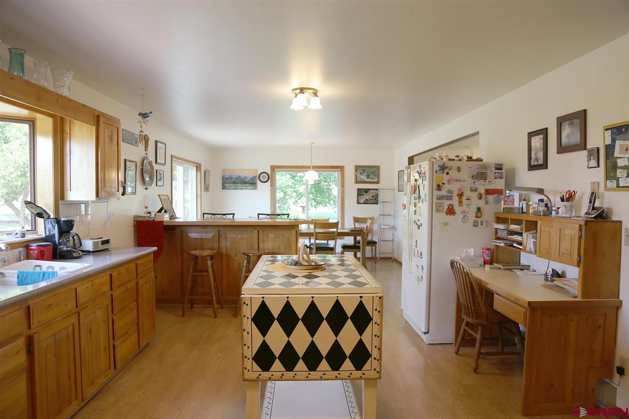 3946 1550 Road Delta, CO 81416 - Photo 9 of 35 a large kitchen with a table chairs and a refrigerator