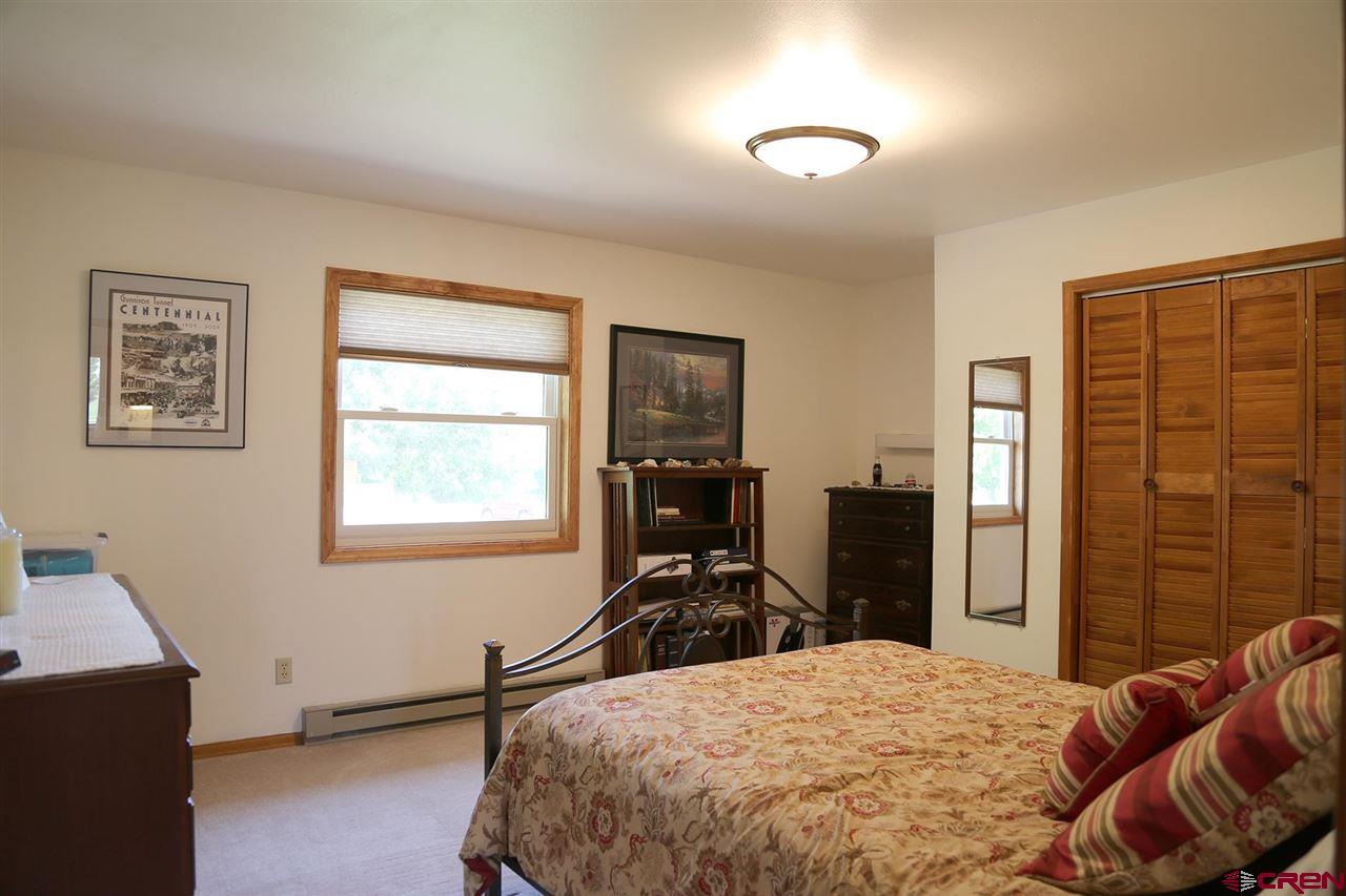 3946 1550 Road Delta, CO 81416 - Photo 10 of 35 a bedroom with a bed and wooden floor