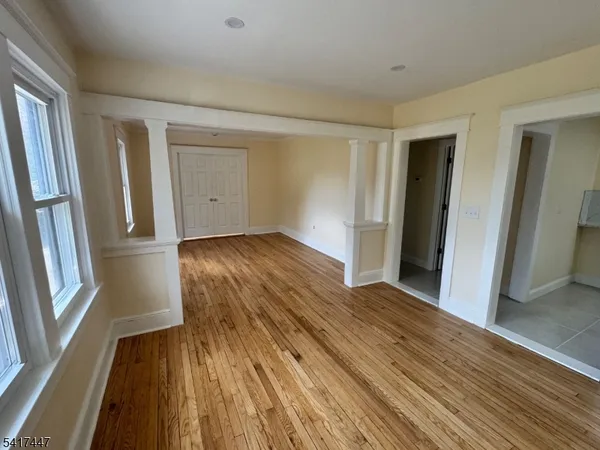an empty room with wooden floor and entrance
