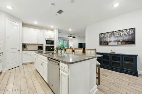 a kitchen with granite countertop white cabinets and white appliances
